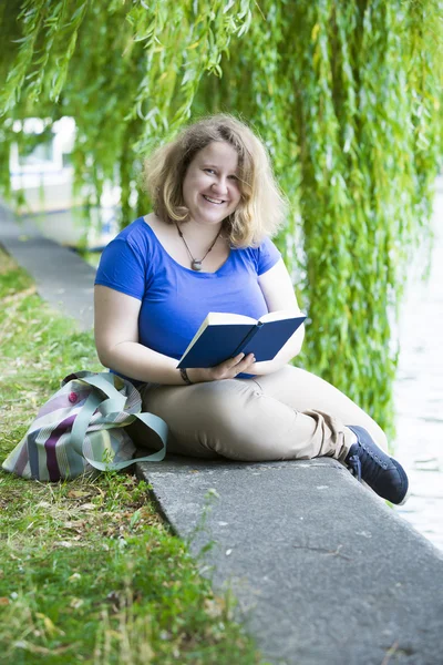 Ung kvinna läser en bok — Stockfoto