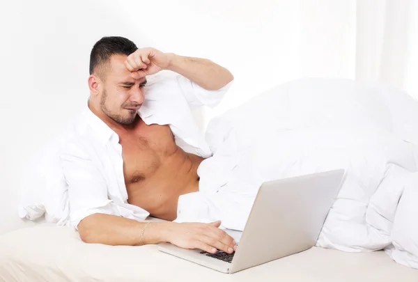 Hombre en la cama con portátil — Foto de Stock