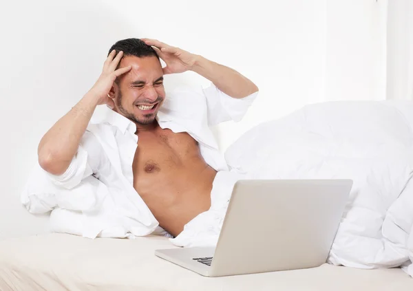 Muž v posteli s notebookem — Stock fotografie