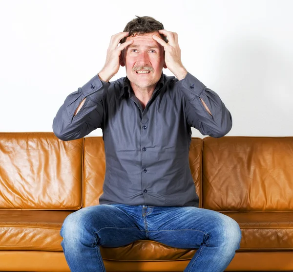 Man sitting on couch — Stock Photo, Image