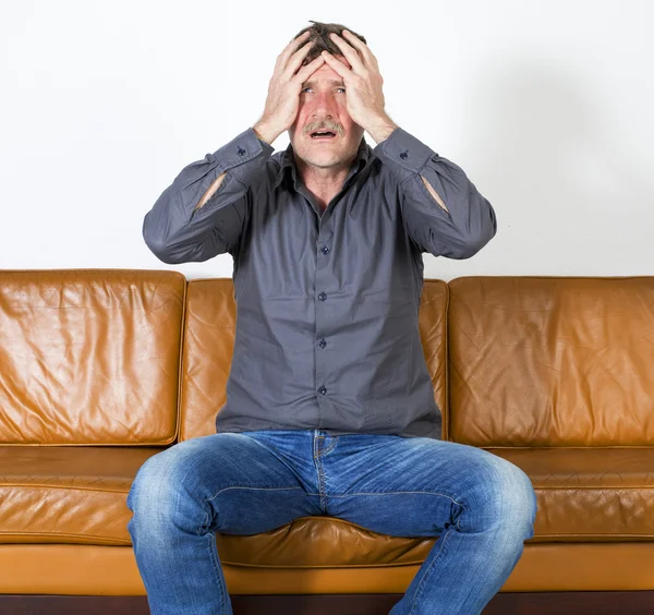 Hombre sentado en el sofá —  Fotos de Stock