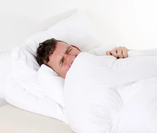Ember az ágyban alszik — Stock Fotó