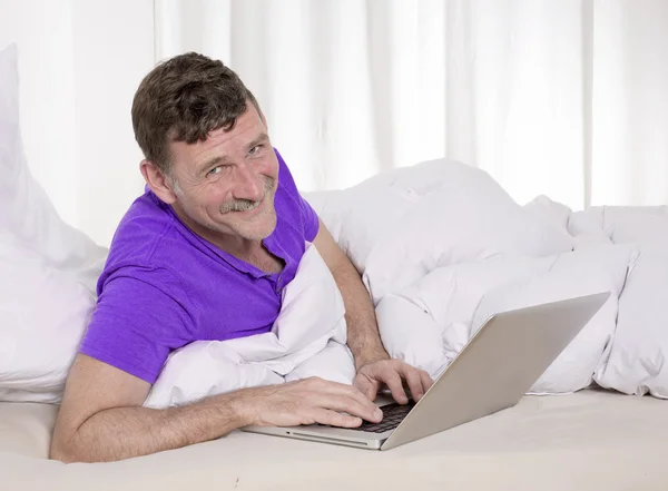 Man in bed with laptop — Stock Photo, Image