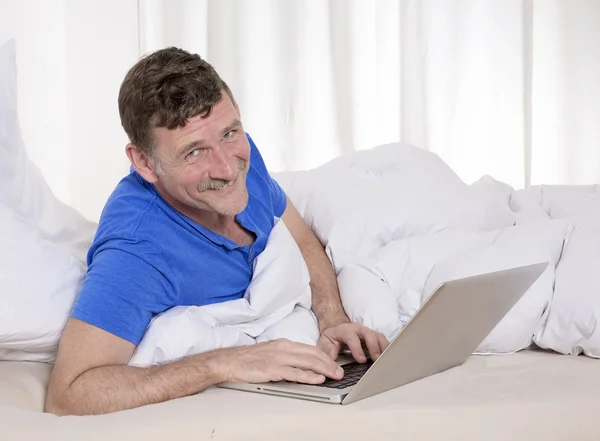 Άνθρωπος στο κρεβάτι με το lap-top — Φωτογραφία Αρχείου