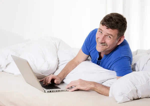 Mann im Bett mit Laptop — Stockfoto