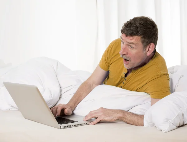 Homem na cama com laptop — Fotografia de Stock