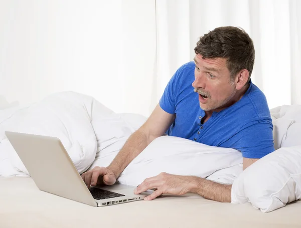 Homem na cama com laptop — Fotografia de Stock