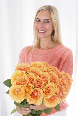 Gülleri olan sarışın kadın.