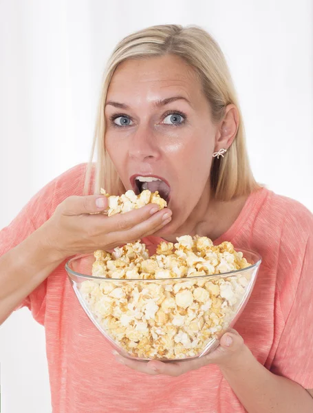 Mujer rubia comiendo palomitas de maíz — Foto de Stock