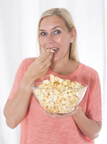 Mujer rubia comiendo palomitas de maíz —  Fotos de Stock