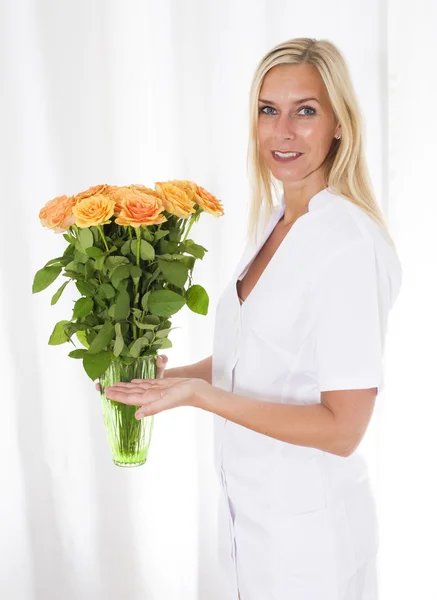 Enfermera trayendo flores — Foto de Stock