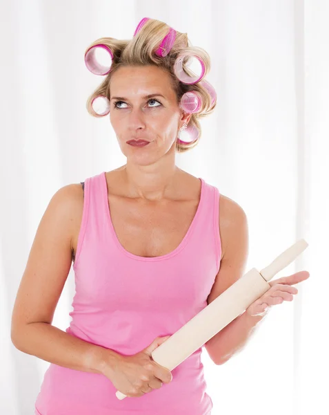 Woman with curlers and a rolling pin — Stock Photo, Image