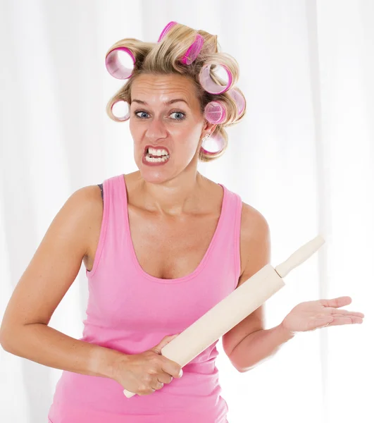 Woman with curlers and a rolling pin — Stock Photo, Image