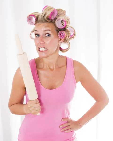 Woman with curlers and a rolling pin — Stock Photo, Image