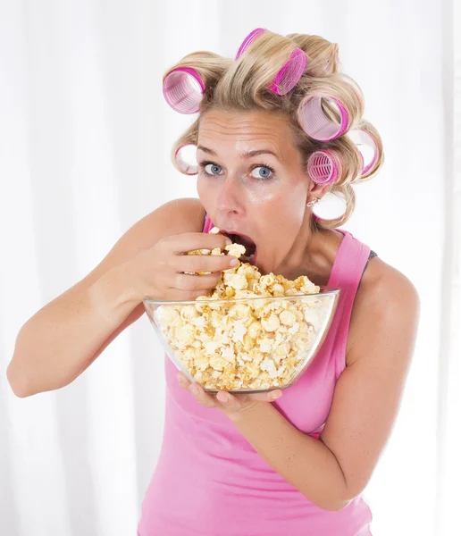 Frau mit Lockenwickler isst Popcorn — Stockfoto
