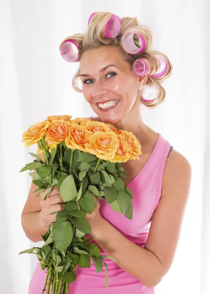 Mujer con rizadores y un ramo de rosas — Foto de Stock