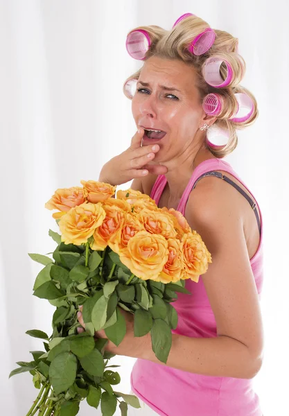 Femme avec des bigoudis et un bouquet de roses — Photo