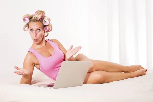 Kvinna med papiljotter och laptop — Stockfoto