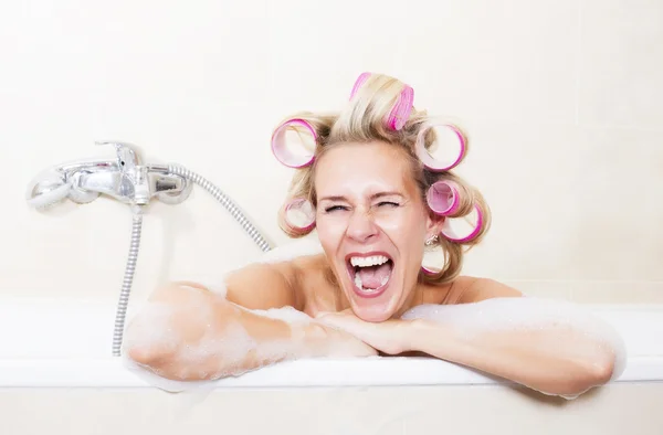 Vrouw met krulspelden in badkuip — Stockfoto