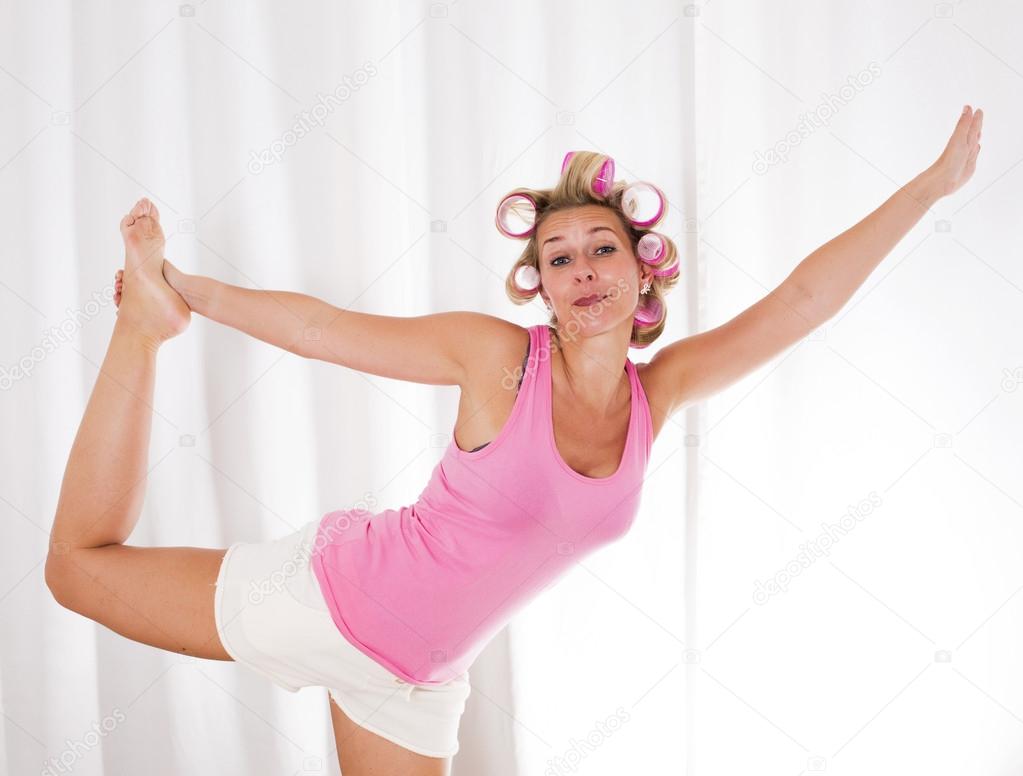 woman with pink curlers is dancing