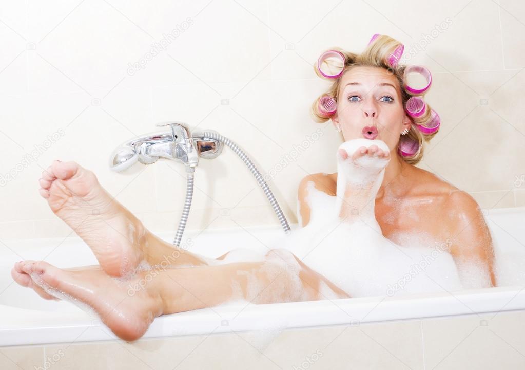 Woman with curlers in bathtub