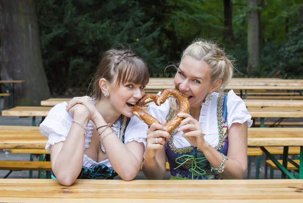 Zwei Frauen im Dirndl mit Brezel — Stockfoto