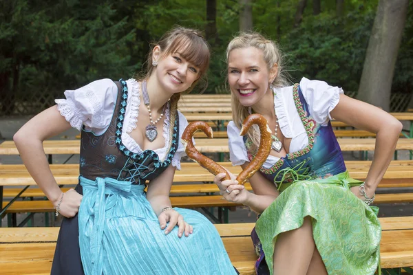 Two woman in dirndl with pretzel — Stock Photo, Image