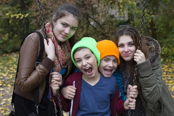 Meninas adolescentes e dois meninos no playground — Fotografia de Stock