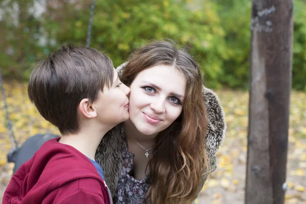 Ragazzo baci adolescente ragazza su il suo guancia — Foto Stock
