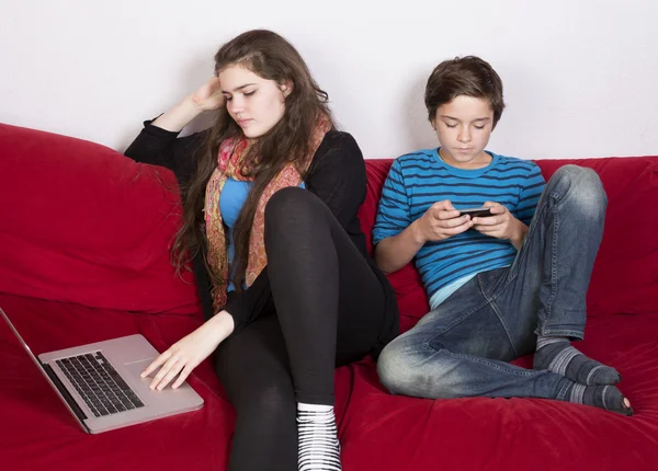 Κορίτσι και αγόρι με φορητό υπολογιστή και το τηλέφωνο — Φωτογραφία Αρχείου