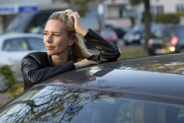 Femme blonde debout près d'une voiture — Photo