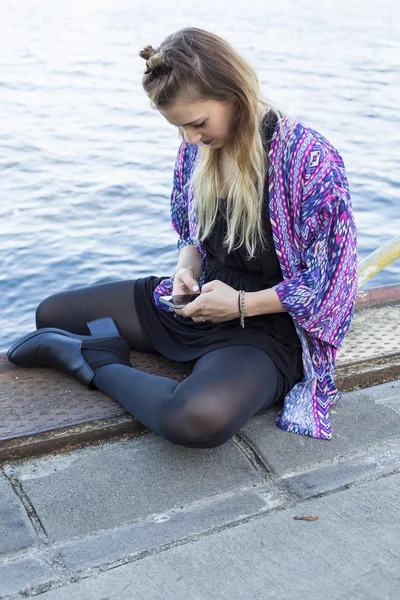 Mladá žena při pohledu na její telefon — Stock fotografie