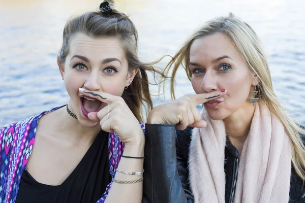 Twee vrouwen met een geschilderde snor — Stockfoto