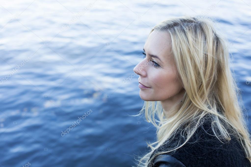 blond woman by the waterfront