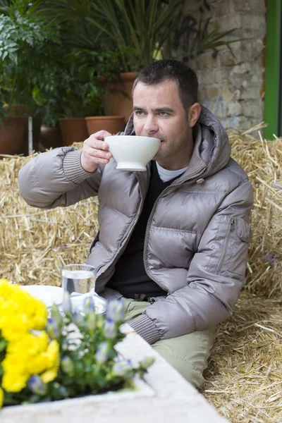 Man sitting outside with a cup in his hands — Stock Photo, Image