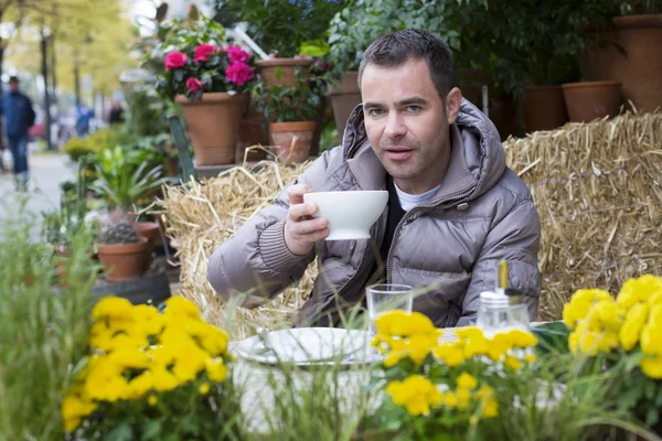 Man zit buiten met een kop in zijn handen — Stockfoto