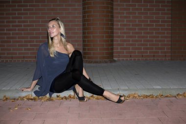 bir kaldırım kenarında oturan kadın