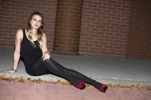 Woman sitting on a curb — Stock Photo, Image