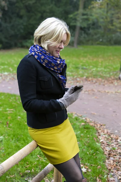 Mujer en el parque con un teléfono —  Fotos de Stock