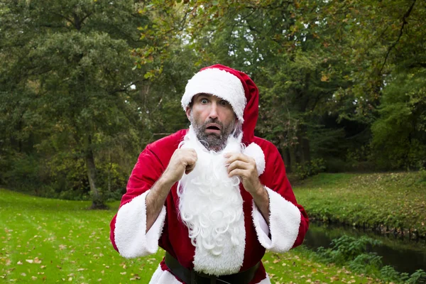 Surprised Santa Claus in a park — Stock Photo, Image