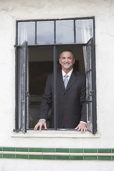 Empresario mirando por una ventana — Foto de Stock