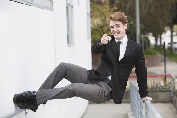 Man in pak springen op een muur — Stockfoto