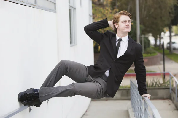 Mann im Anzug springt gegen Wand — Stockfoto