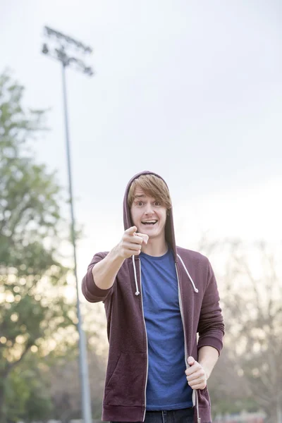 Young man in a hoodie pointing his finger — Stock Photo, Image