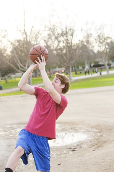 Jongeman die basketbal speelt — Stockfoto