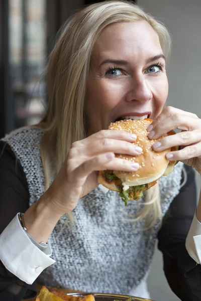 Kvinna med en hamburgare — Stockfoto