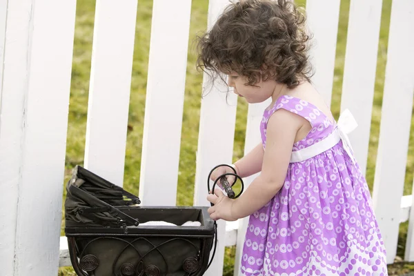 Liten flicka trycka en vintage barnvagn — Stockfoto