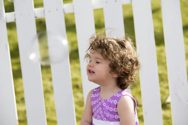 Little curly girl with soap bubbles — Stock Photo, Image