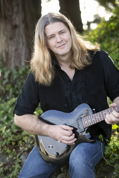 Man met de gitaar op de straat — Stockfoto