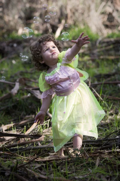 Meisje gekleed als een sprookje met zeepbellen — Stockfoto